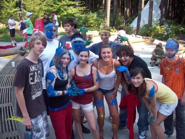 Teens laughing together covered in blue paint after a group challenge