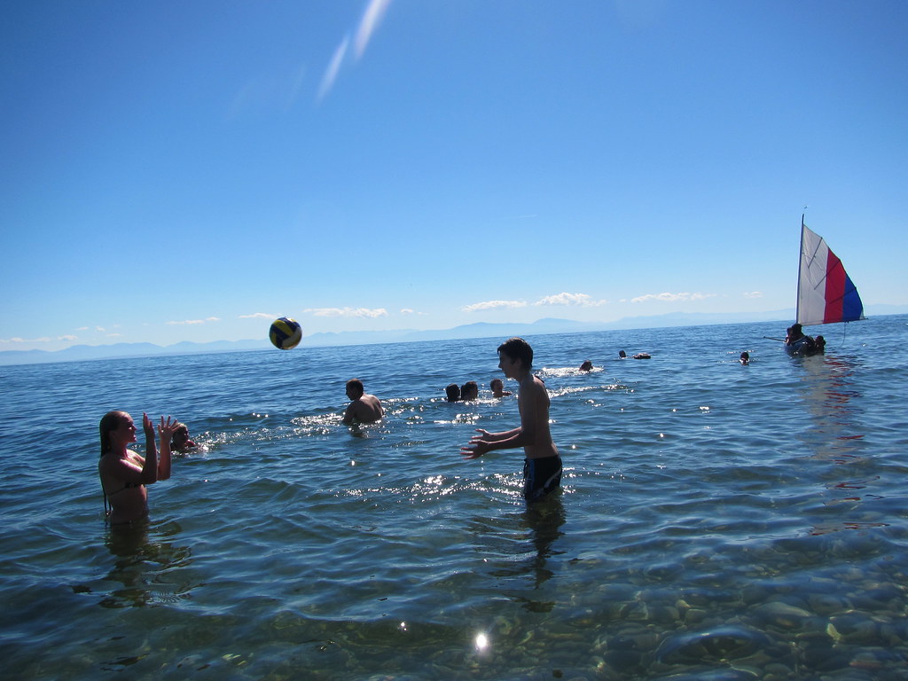 Water volleyball with sailboat in the background